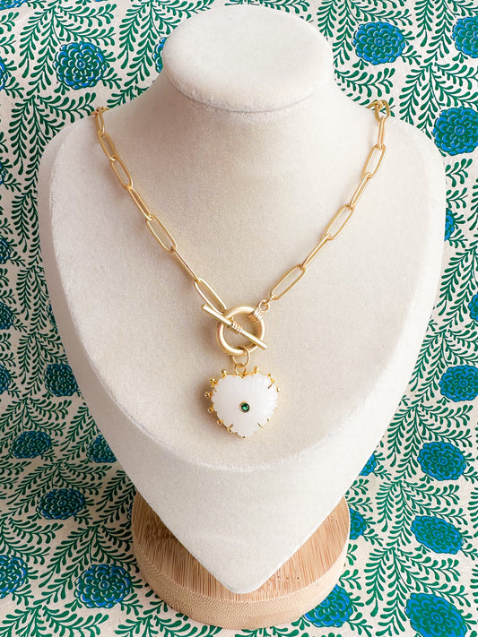 Gold paper clip necklace with a toggle clasp and heart-shaped carved chalcedony pendant.